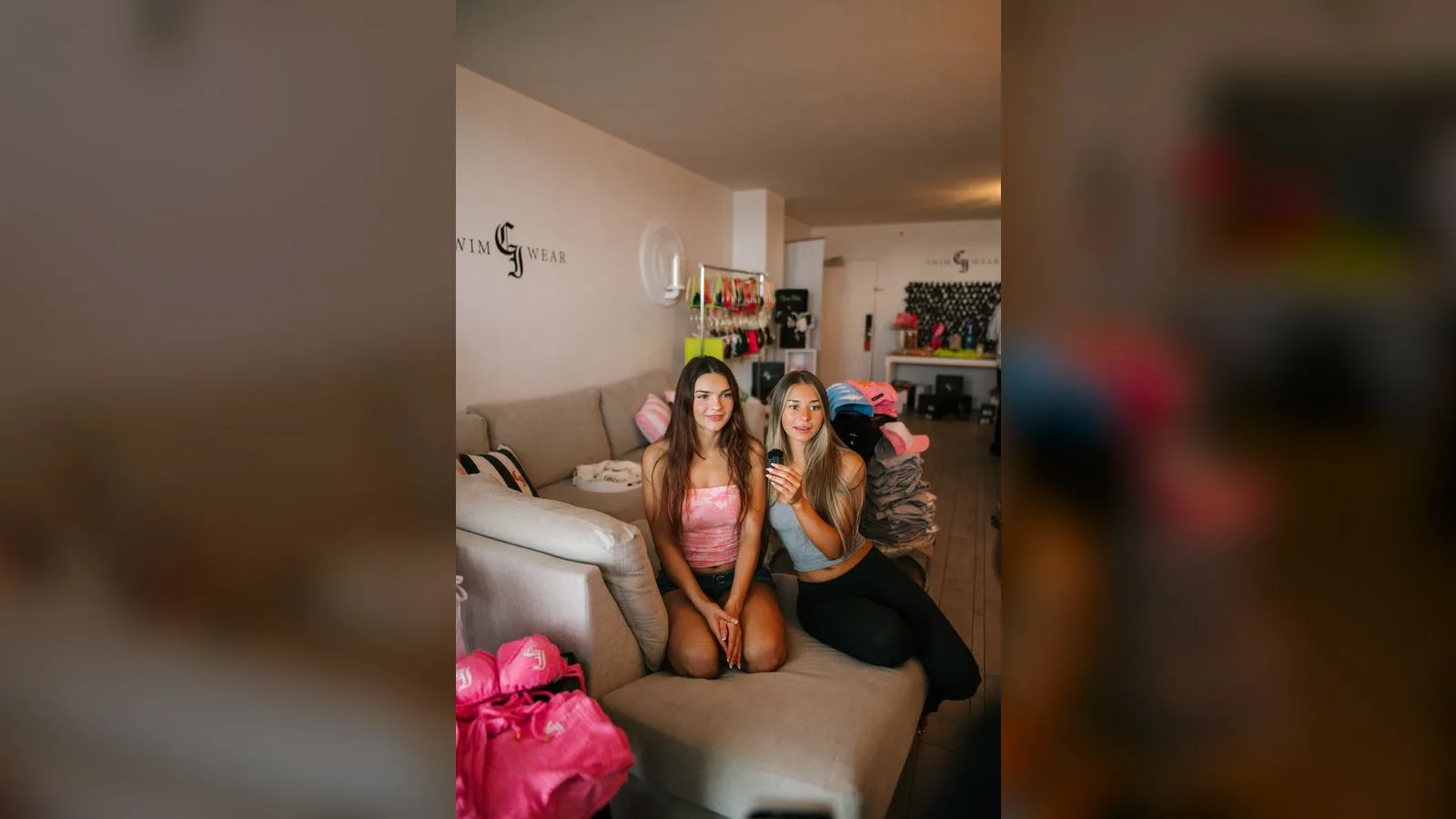 Two creators sitting together on a couch in the CI Swimwear lounge